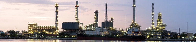 Silhouette of an illuminated industrial estate at dusk  